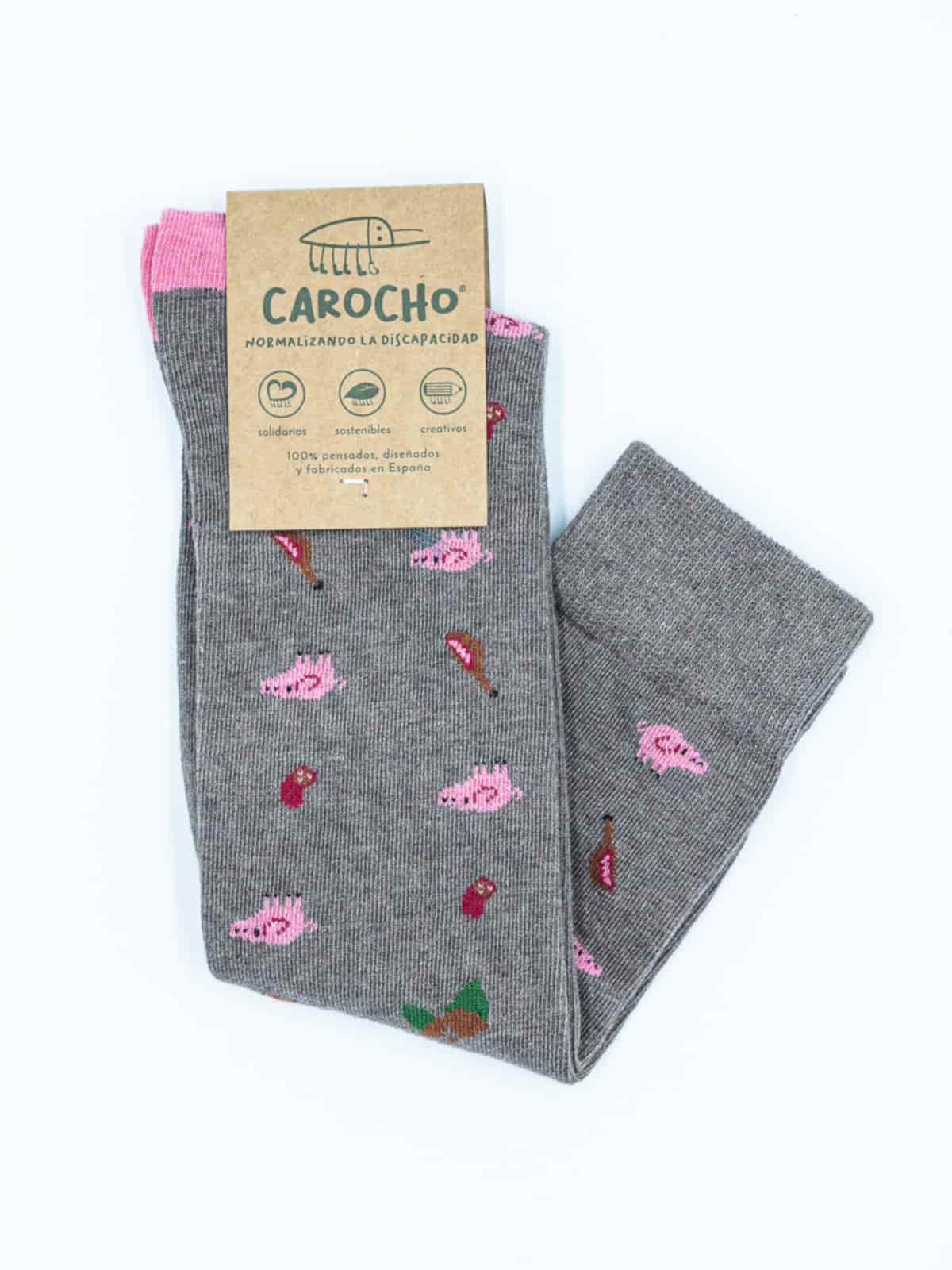 Paseando entre las encinas y alcornoques de las dehesas extremeñas realizamos una selección de productos que producirán en tus pies la mayor diversión posible dibujando cerdos, jamones y chorizos en unos calcetines ibéricos marrones con puntera y talón rosa.